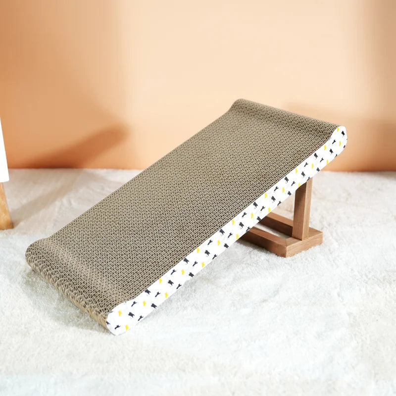 Griffoir carton à bords relevés installé en plan incliné sur un pied en bois, tapis blanc et mur orangé