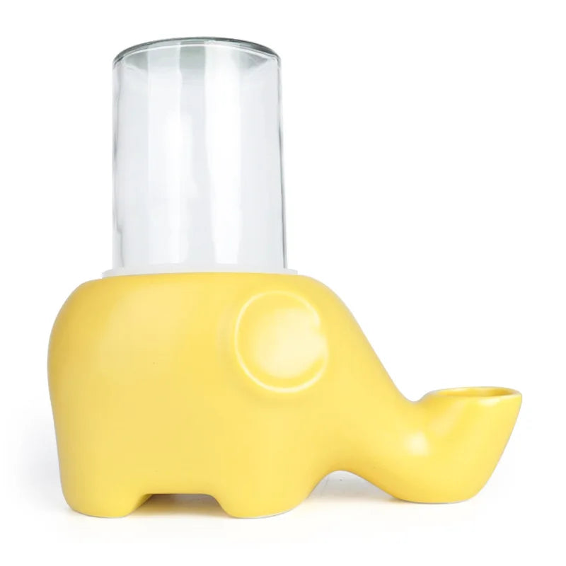 Abreuvoir éléphant jaune en céramique mate pour chat, avec grande bouteille en verre transparent posée sur le dessus