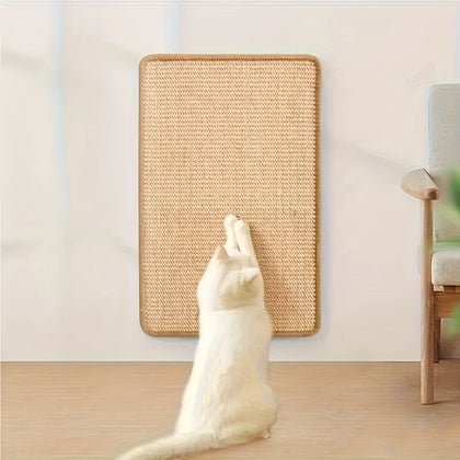Chat blanc dressé sur ses pattes arrière qui se griffe sur un tapis en sisal fixé au mur, salon clair